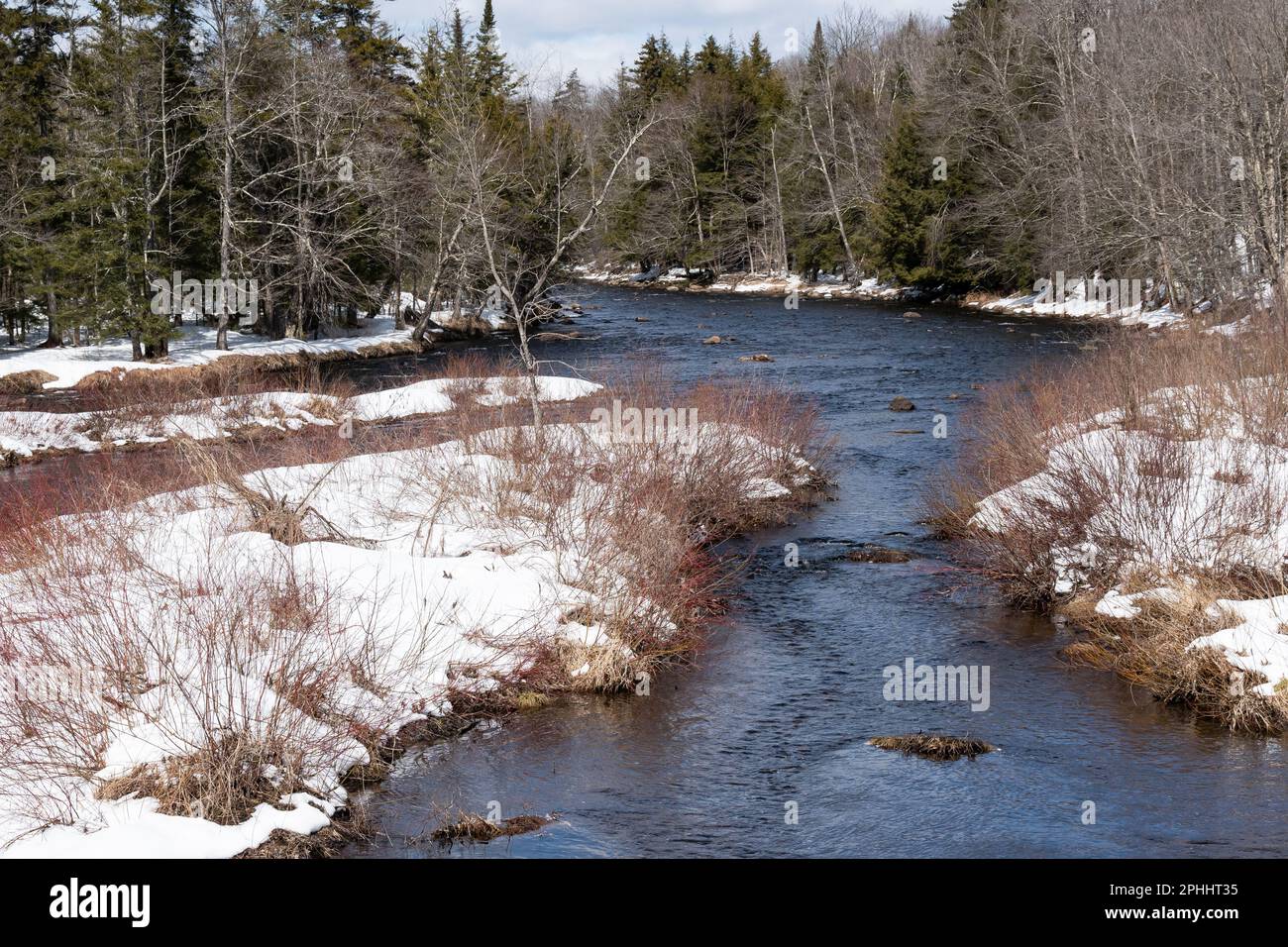 A view of the Sacandaga River in the Adirondack Mountains in late winter with snow covering the ground Stock Photo