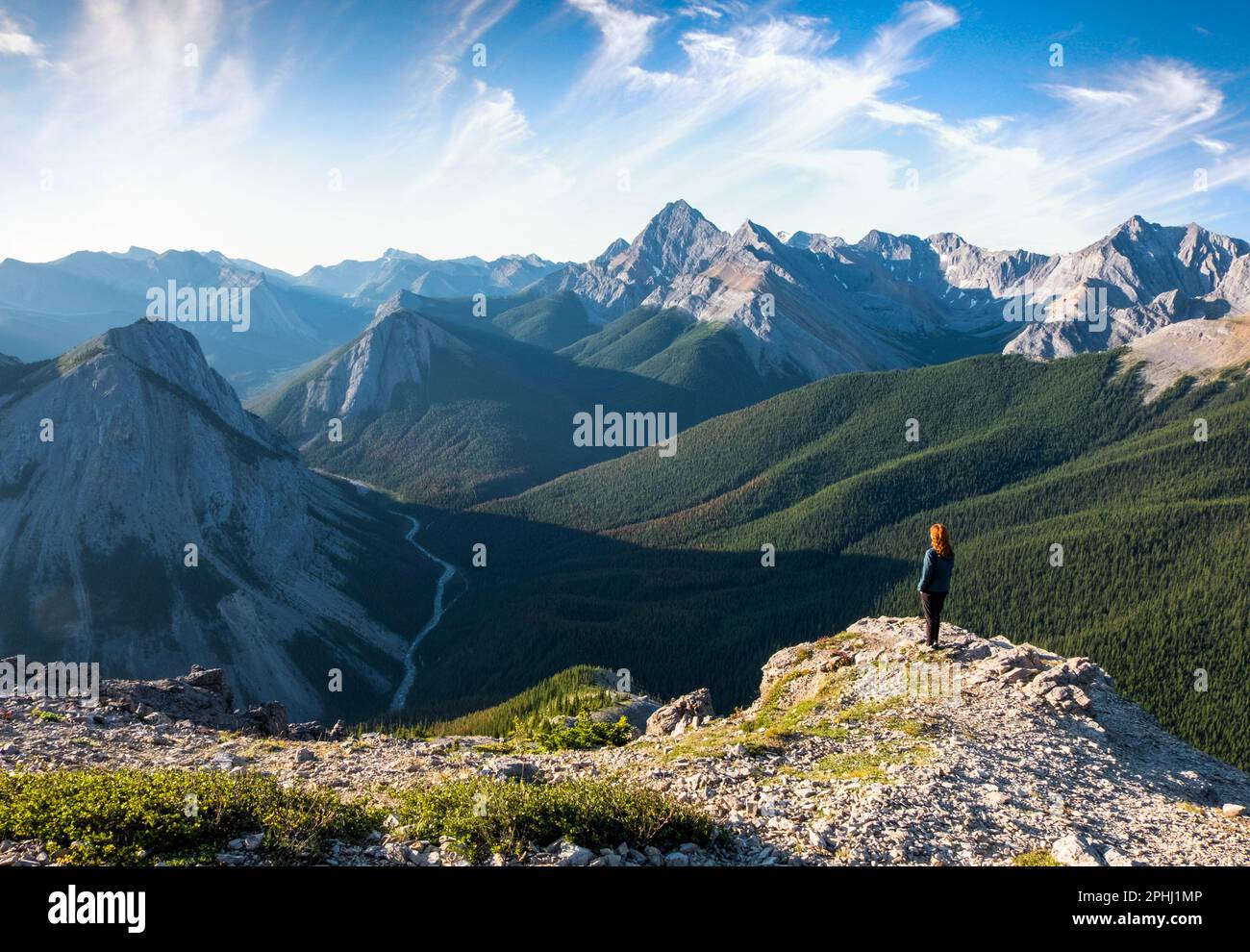 A Woman Hiker looks towards The Canadian Rockies as Viewed From The Sulphur Skyline Summit