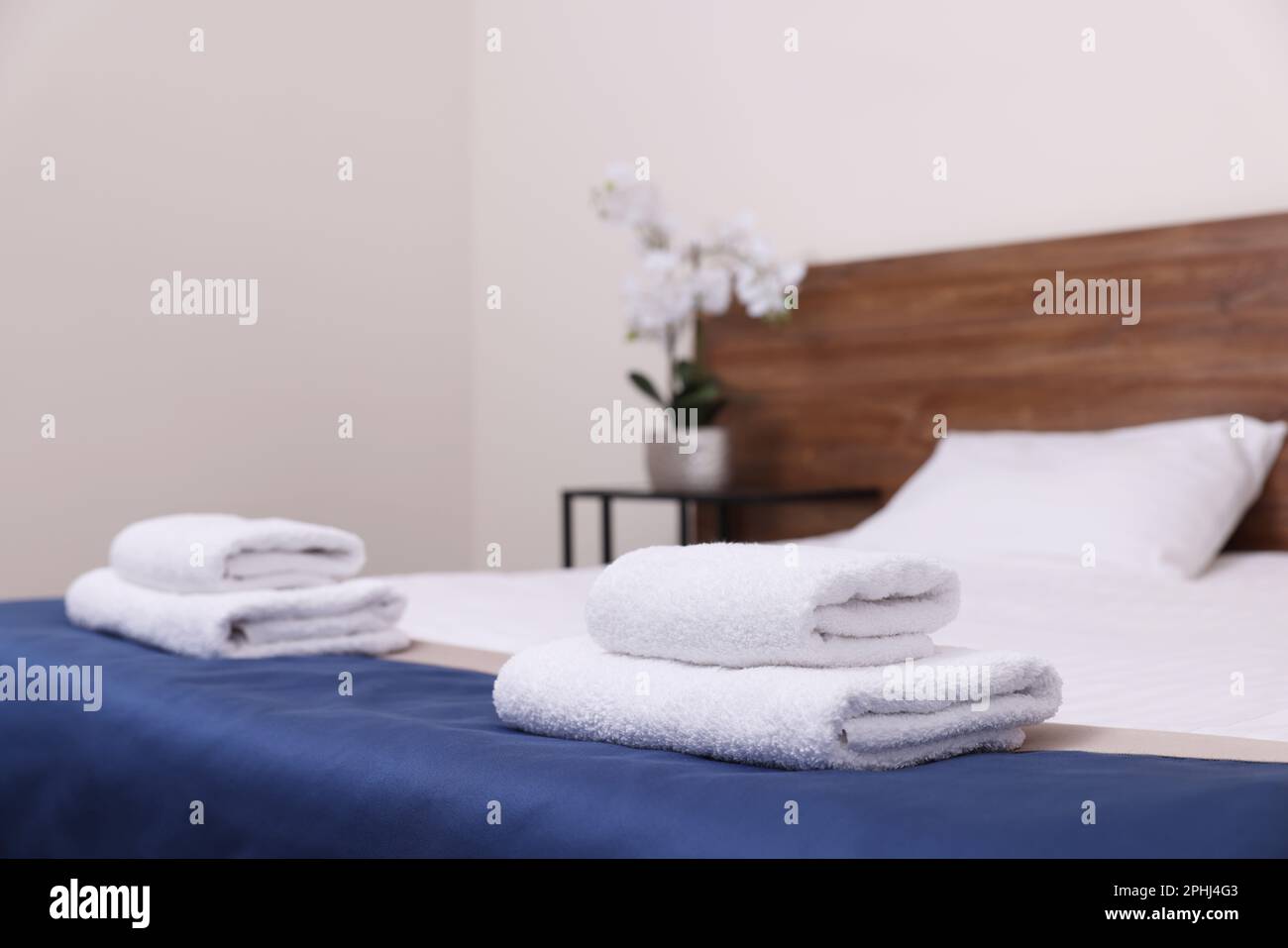 Clean folded towels on bed in hotel room Stock Photo Alamy