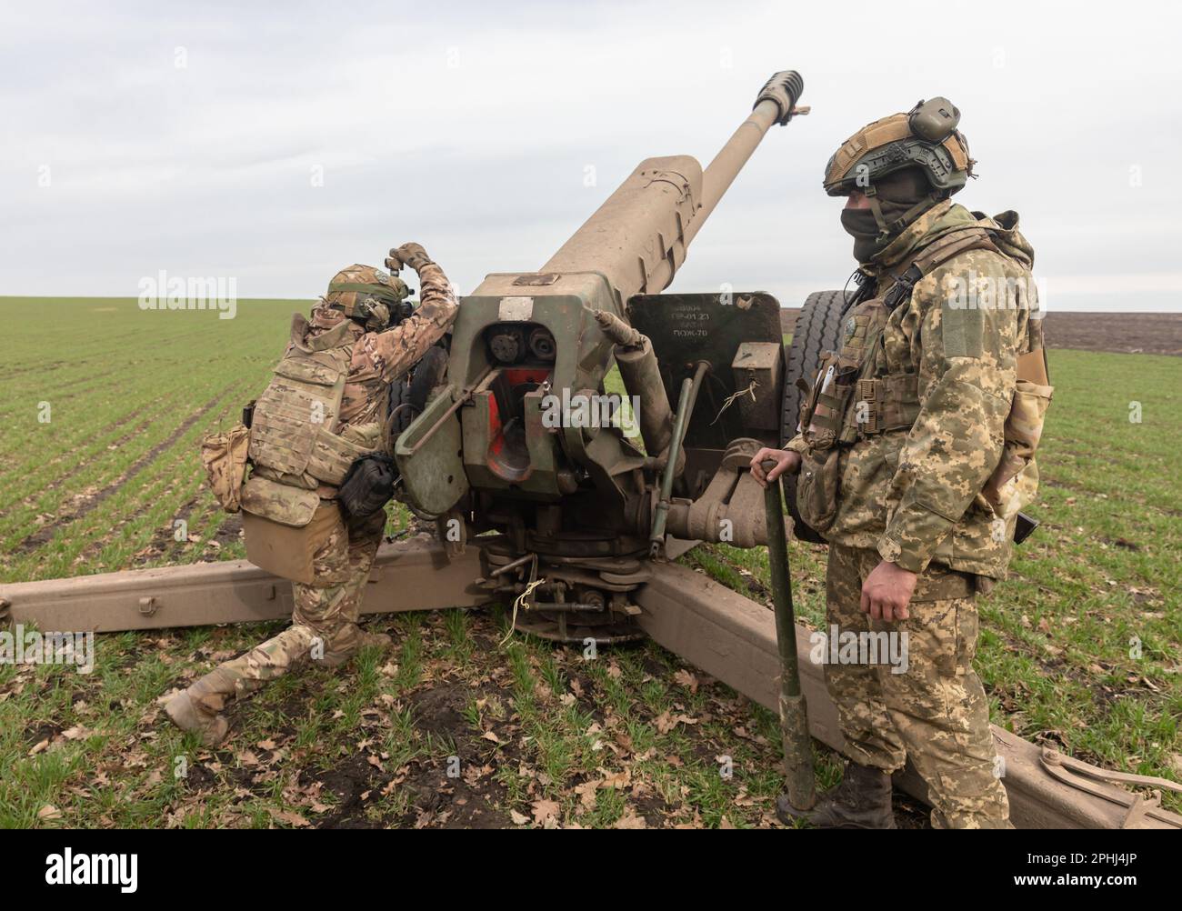 March 21, 2023, Donetsk region, Ukraine: A Ukrainian Armed Forces soldier is seen pointing a 122mm howitzer D-30 at a target before firing. Ukraine's state-owned defense conglomerate, Ukroboronprom, has delivered its first batch of domestically produced 122 mm artillery shells to the Ukrainian army. The 122 caliber projectile is used by the Ukrainian artillery while operating with the trailing D-30 howitzer (maximum range: 15,400 m) and 2S1 Gvozdika SAU (maximum range: 15,200 m). This is part of Ukraine's efforts to increase its self-sufficiency and security by launching its own production of Stock Photo