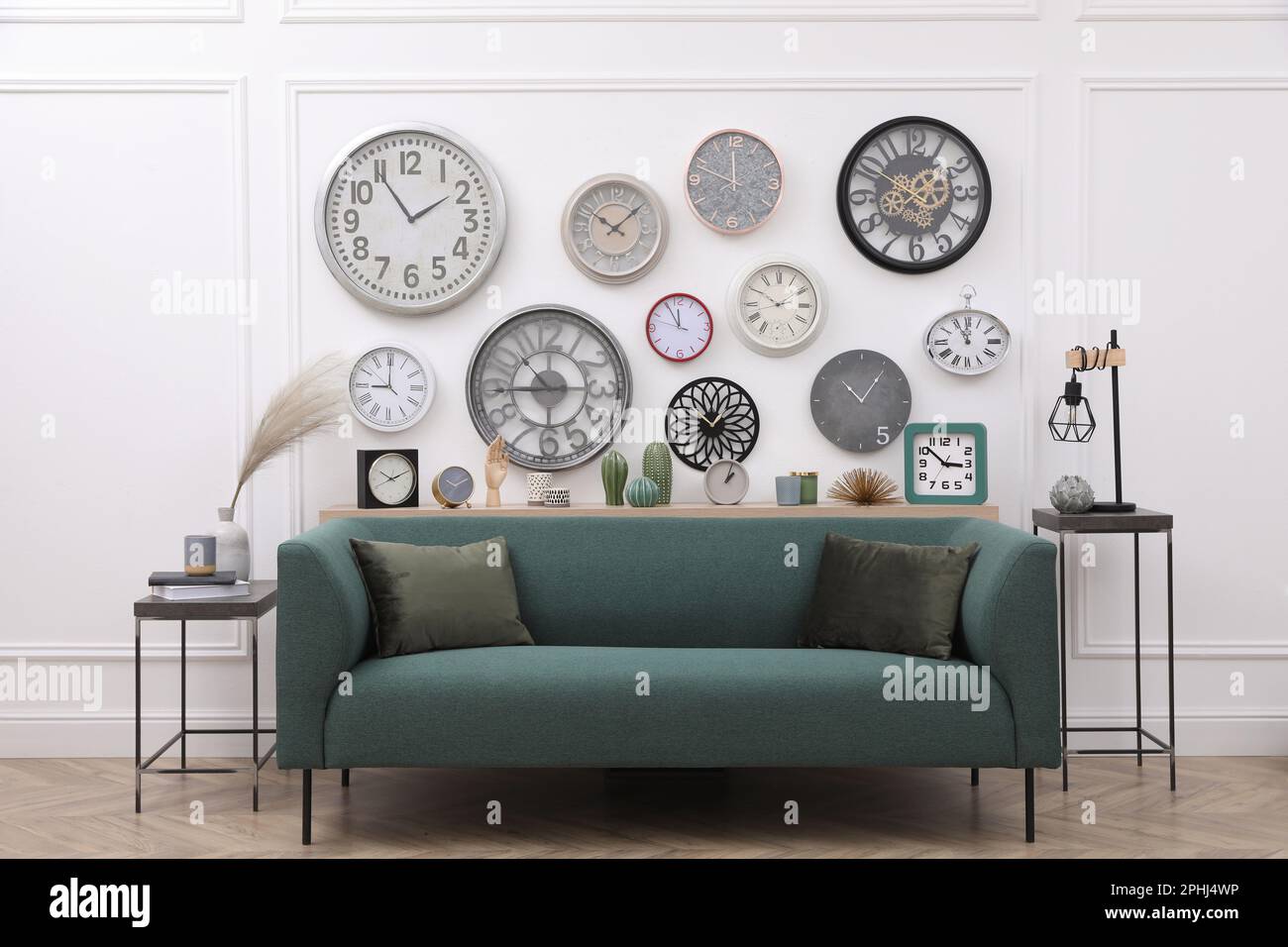 Collection of different clocks and comfortable sofa in stylish room ...