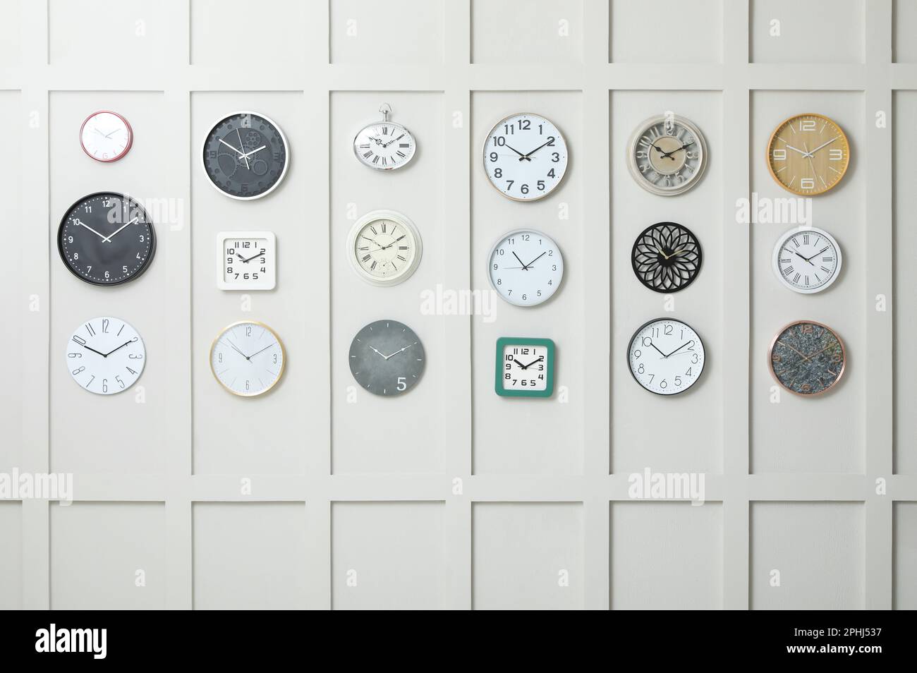 Many different clocks hanging on white wall Stock Photo Alamy