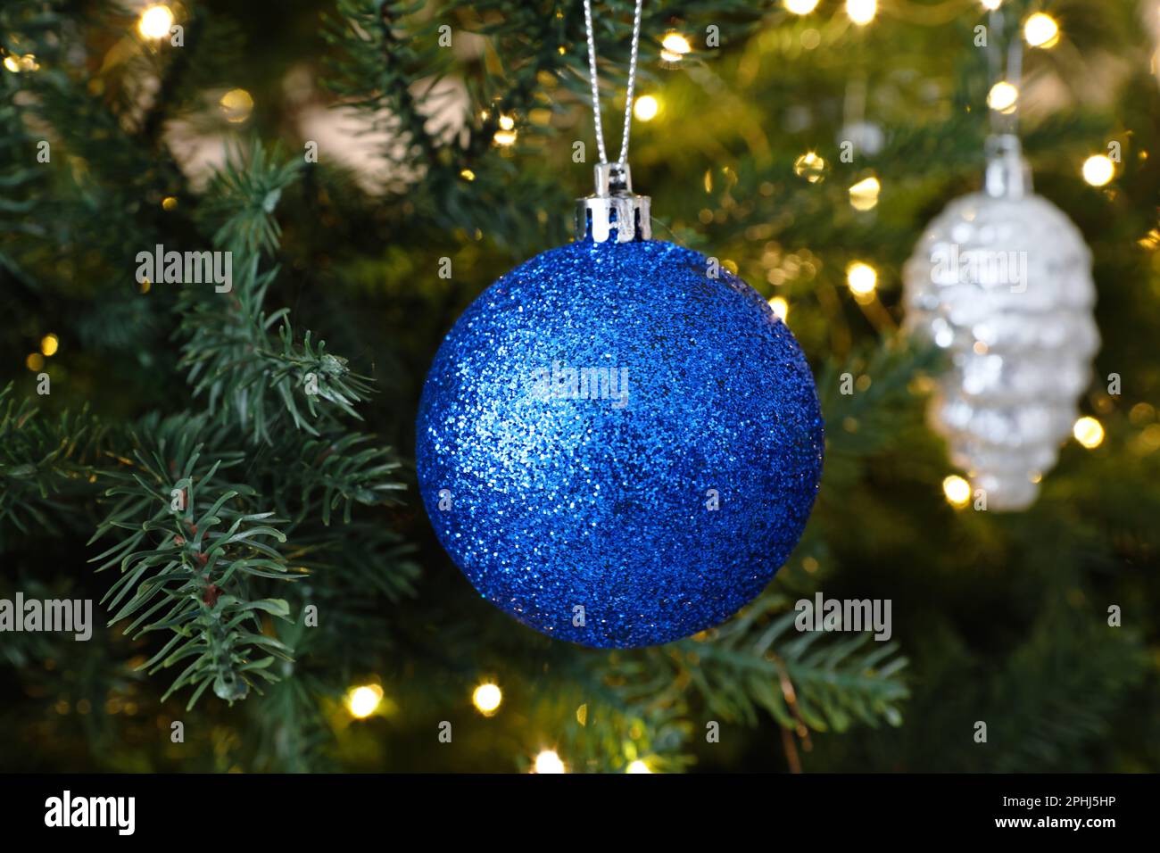 Beautiful blue Christmas ball hanging on fir tree branch, closeup Stock ...