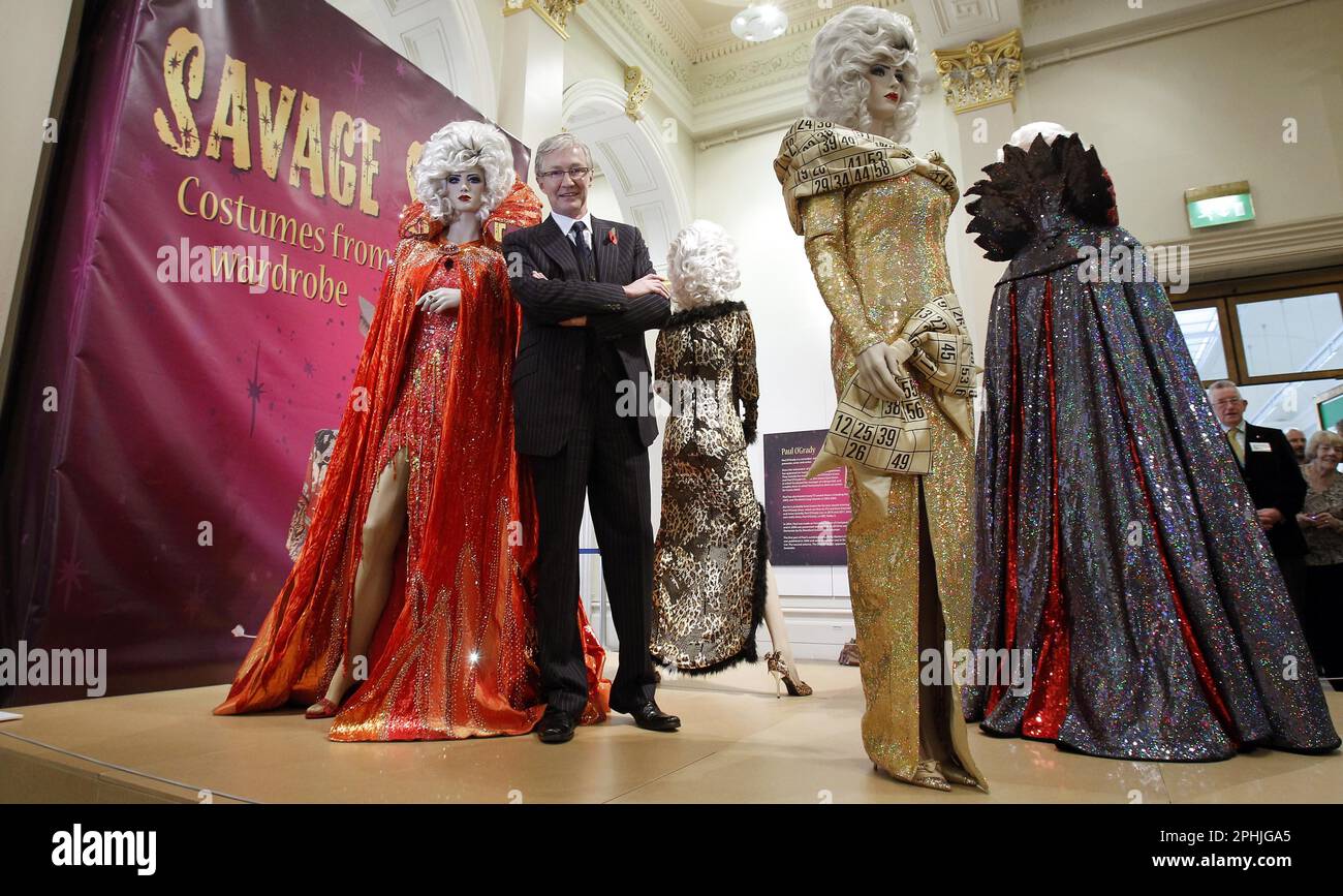 File photo dated 04/11/11 of Paul O'Grady standing next to former costumes of his alter ego Lily Savage at Liverpool's Walker Art Gallery, where they were appearing as part of the Savage Style: Costumes from Lily's Wardrobe exhibition. TV presenter and comedian Paul O'Grady has died at the age of 67, his partner Andre Portasio has said. The TV star, also known for his drag queen persona Lily Savage, died 'unexpectedly but peacefully' on Tuesday evening, a statement shared with the PA news agency via a representative said. Issue date: Wednesday March 29, 2023. Stock Photo