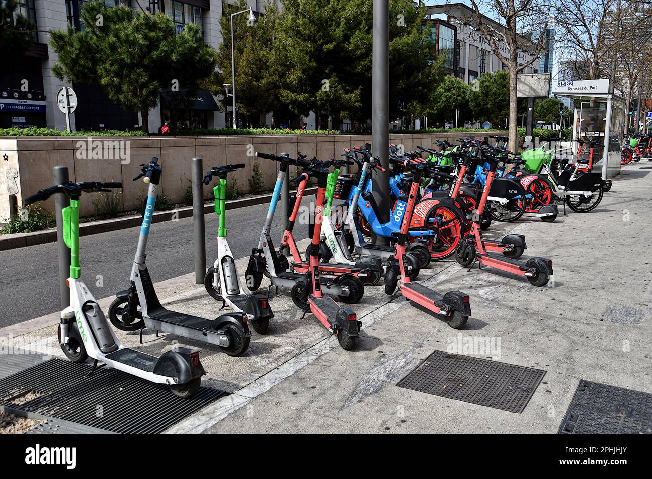 Marseille, France. 23rd Mar, 2023. Electric scooters and bicycles are seen  on a sidewalk in Marseille. Many operators share the e-scooter and the e-bike  market in Marseille. With Bird, Voi, Lime and