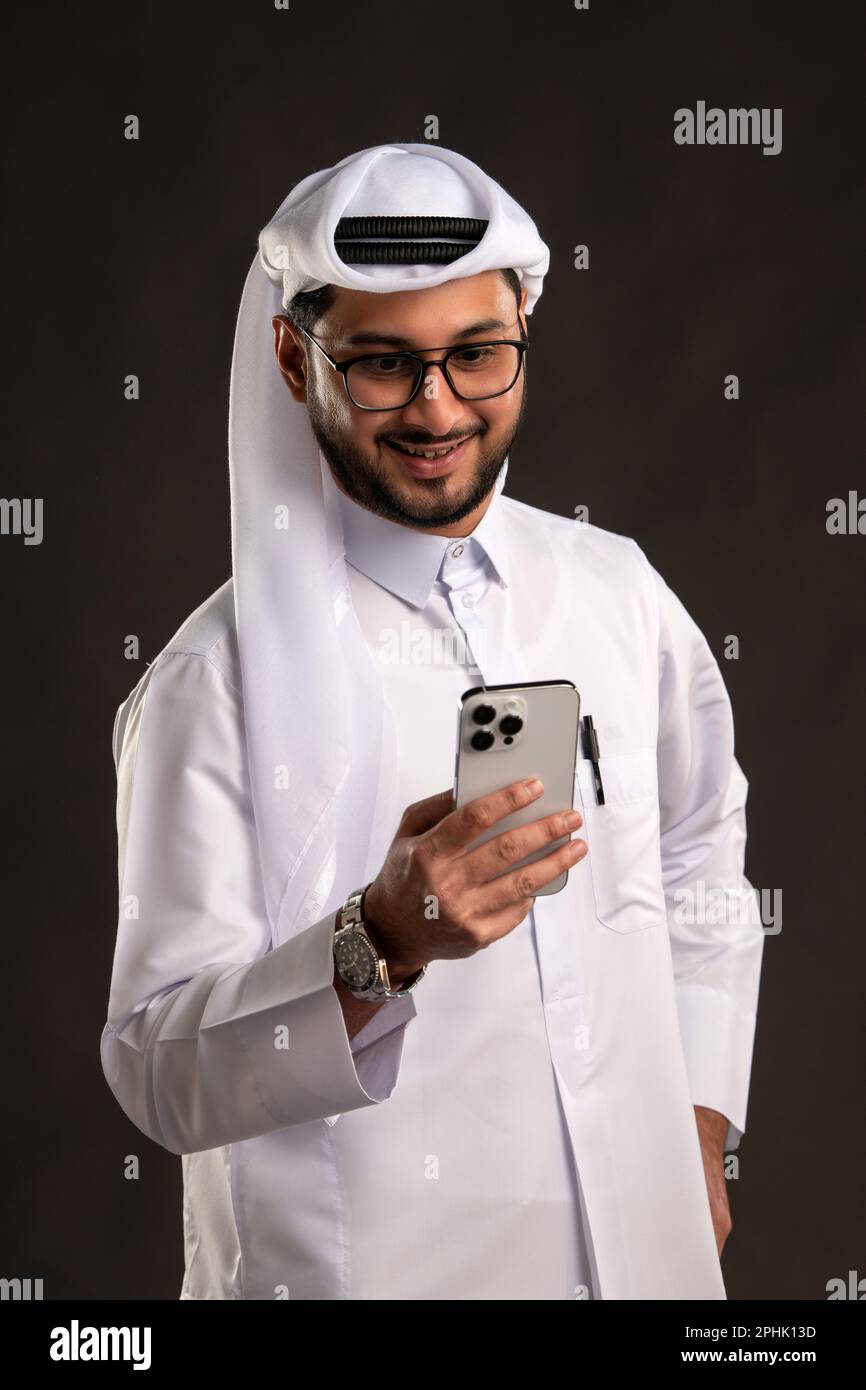 Qatari Man using Phone Tablet on isolated background. Business and ...