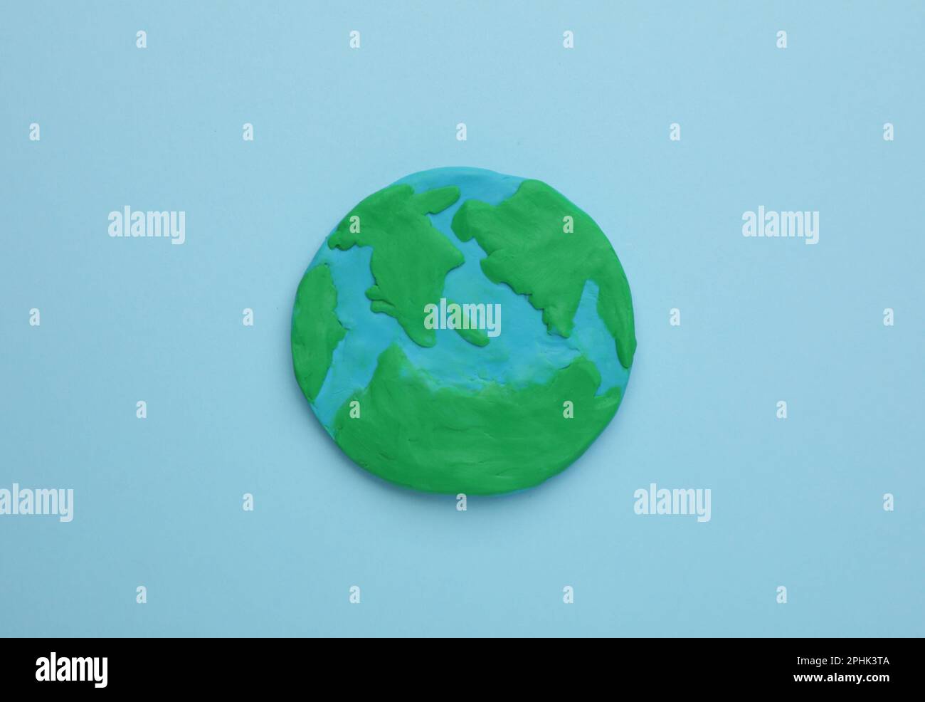 Plasticine model of planet on light blue background, top view. Earth