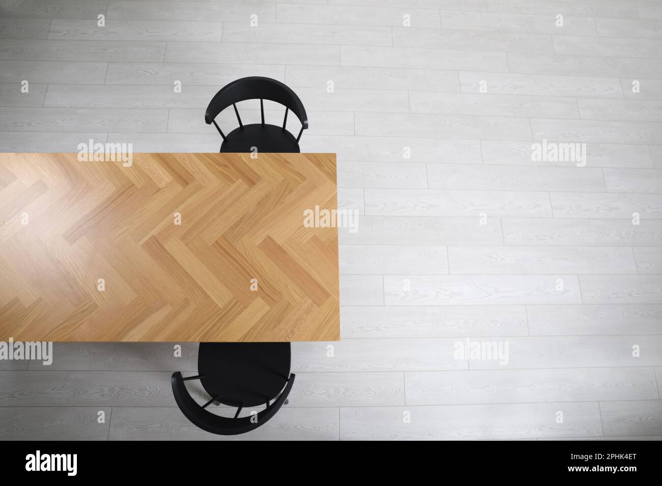 Wooden table and black chairs indoors, top view. Interior design Stock
