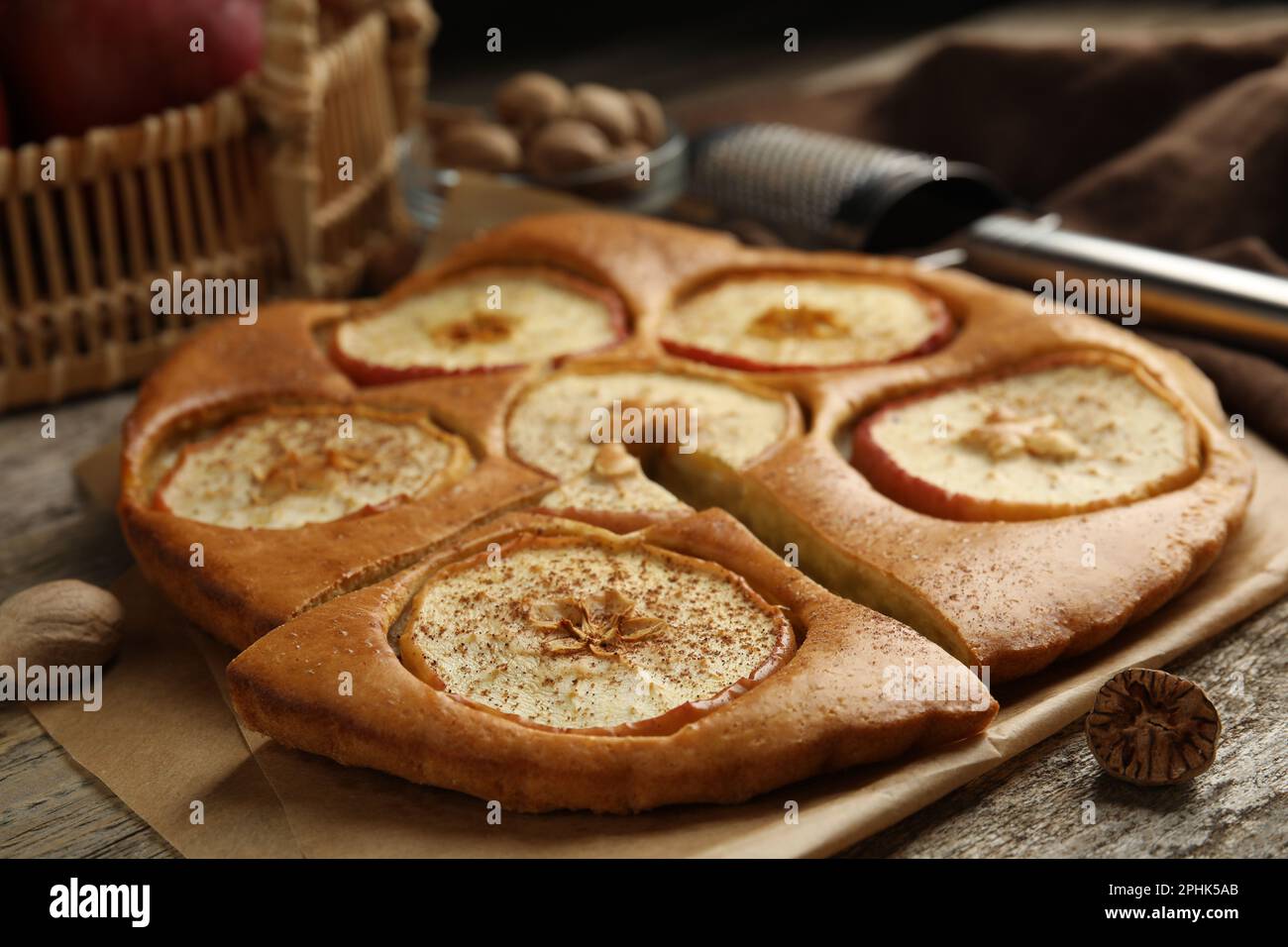 Tasty apple pie with nutmeg powder on wooden table, closeup Stock Photo