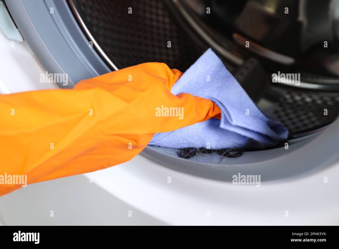 Worker cleaning empty washing machine with rag, closeup Stock Photo Alamy