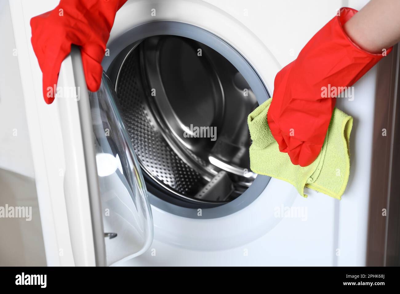 Woman cleaning washing machine with rag, closeup Stock Photo - Alamy