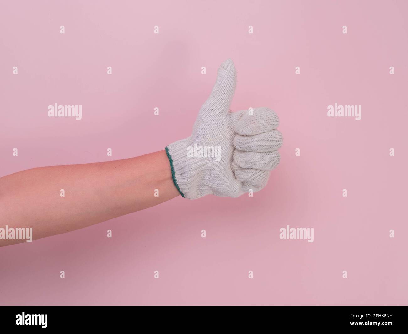 Hands in white knitted gloves isolated on pink background. Female hand