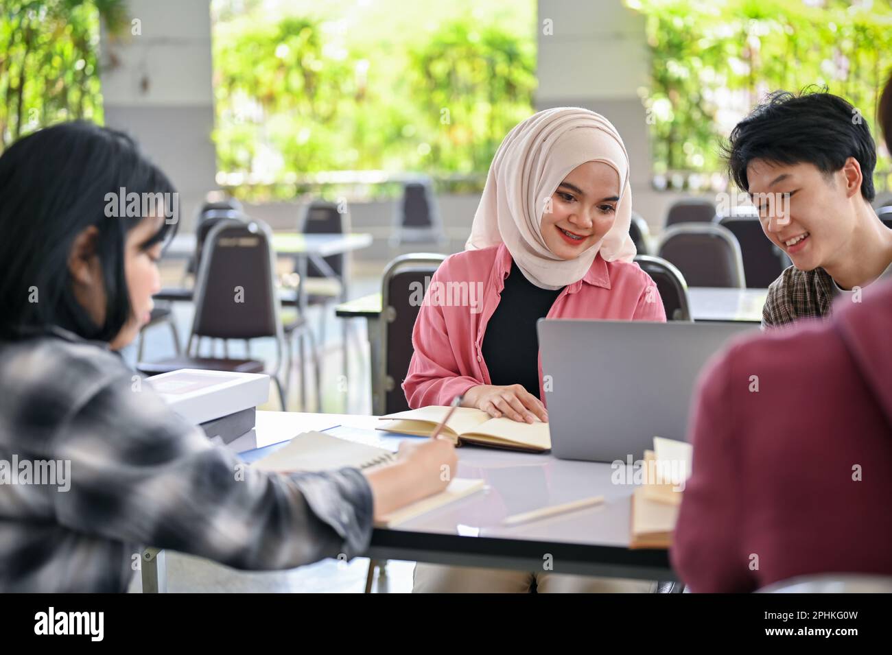 A beautiful young Asian Muslim female college student is doing a school ...