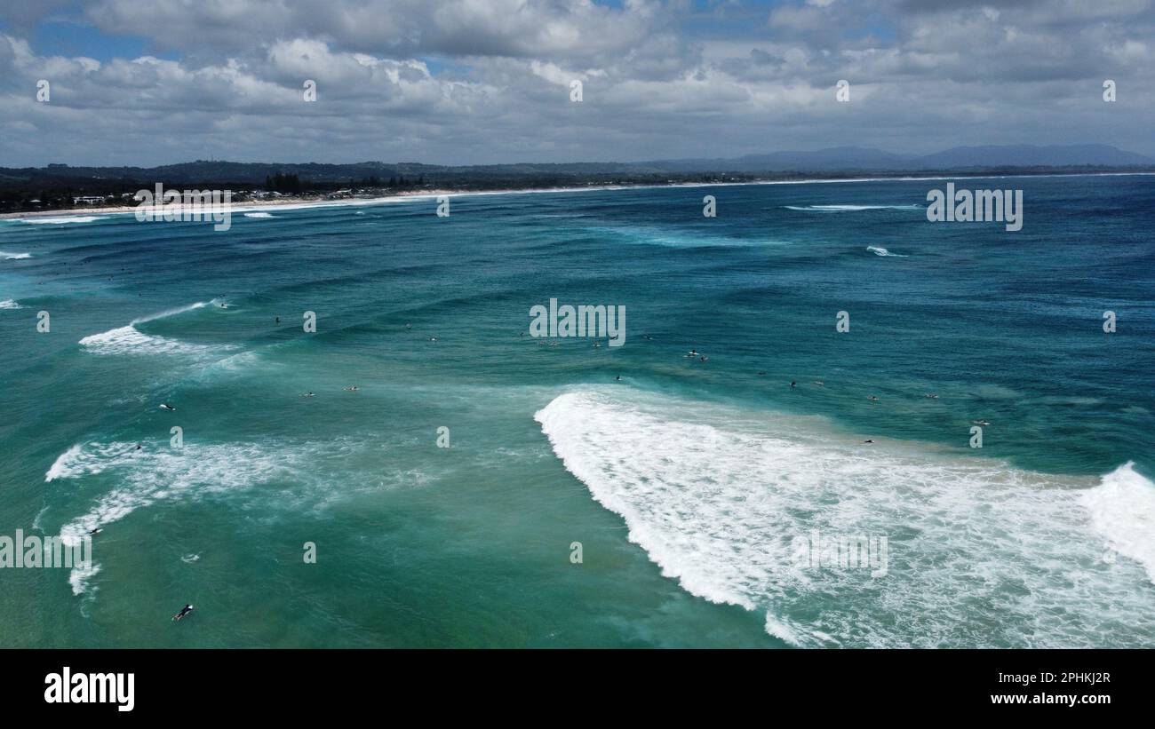 A landscape of the sea surrounded by a beach and greenery under a blue ...