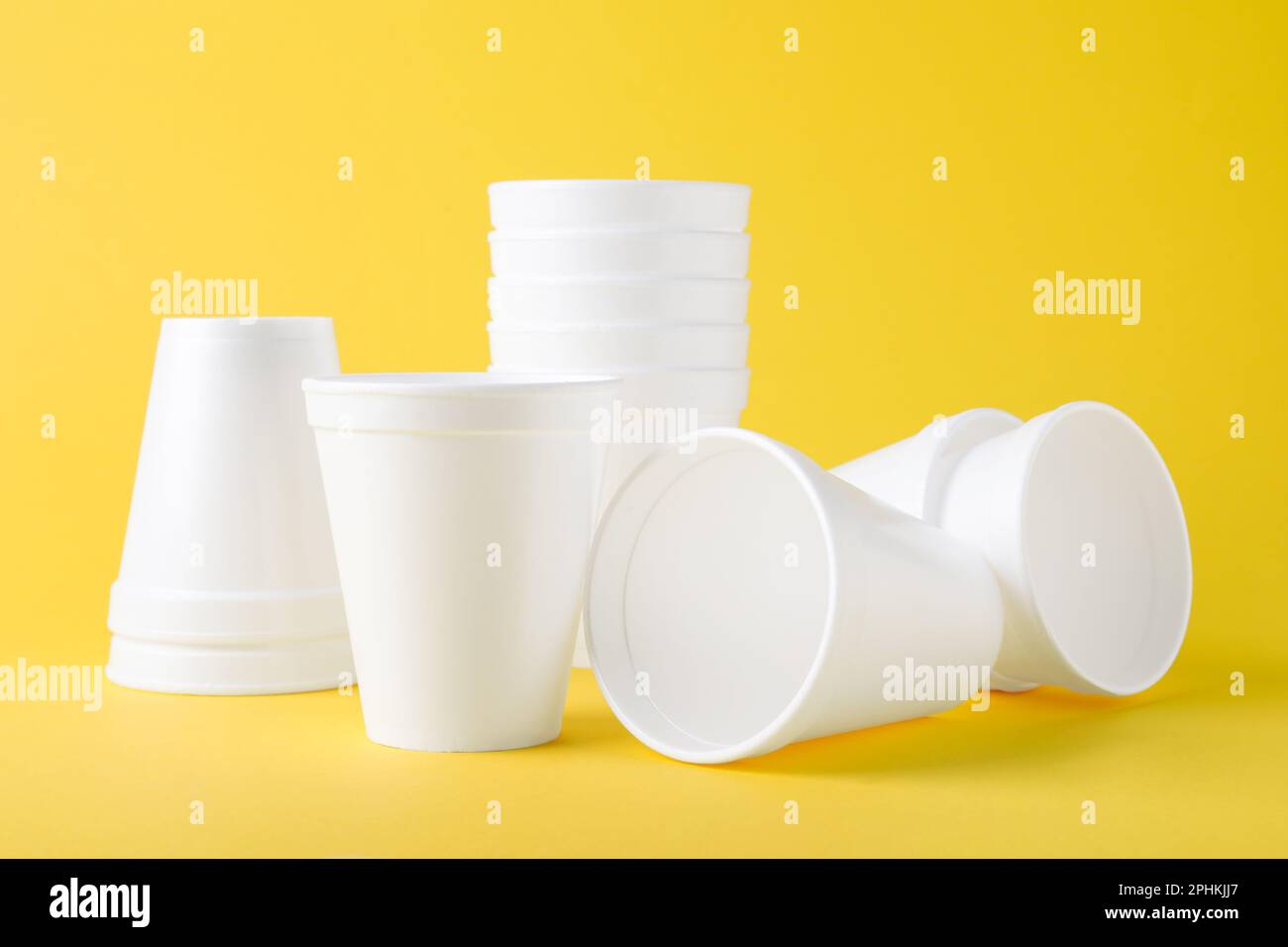 Many white styrofoam cups on yellow background Stock Photo Alamy