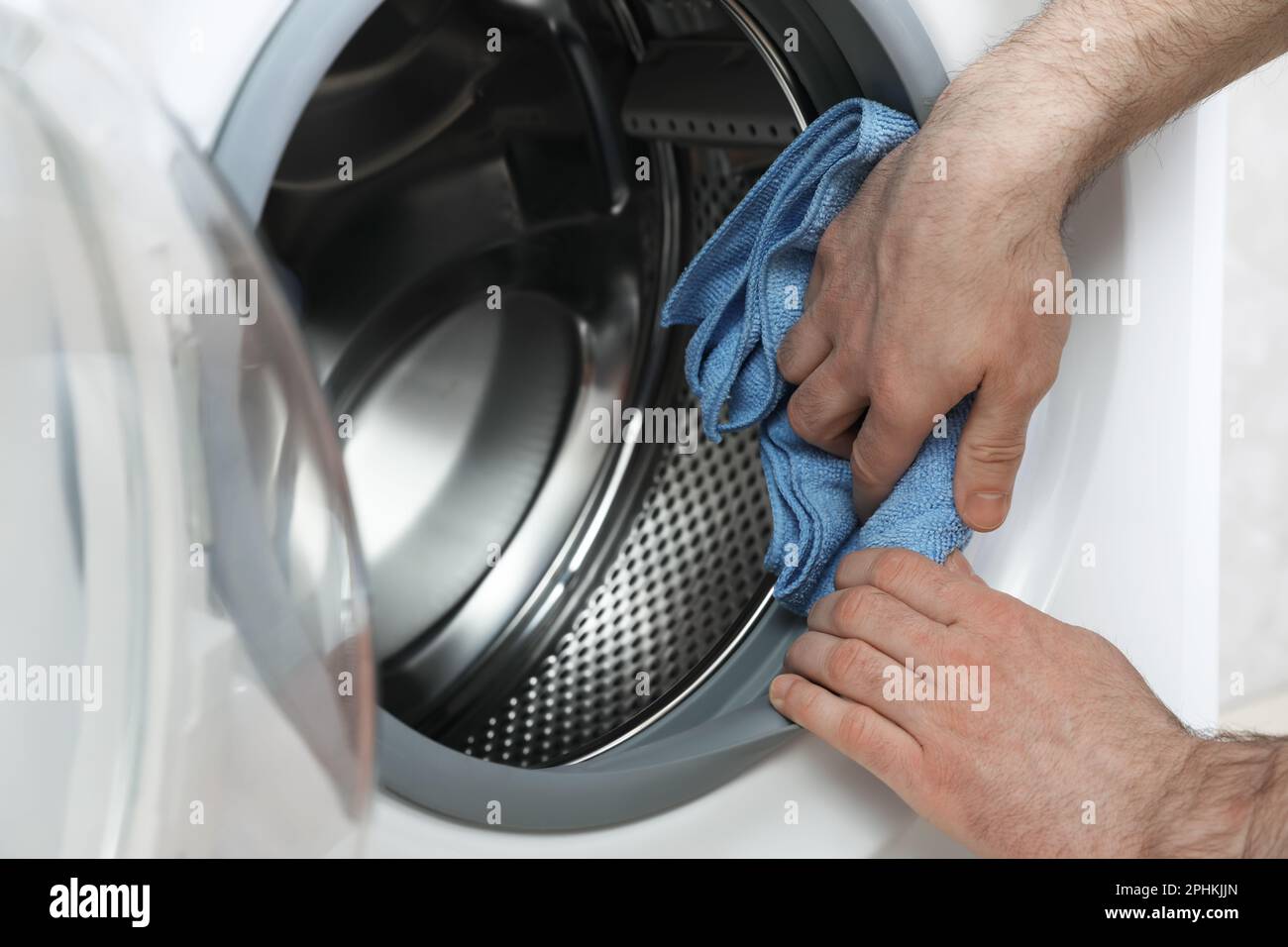 Man cleaning empty washing machine with rag, closeup Stock Photo Alamy