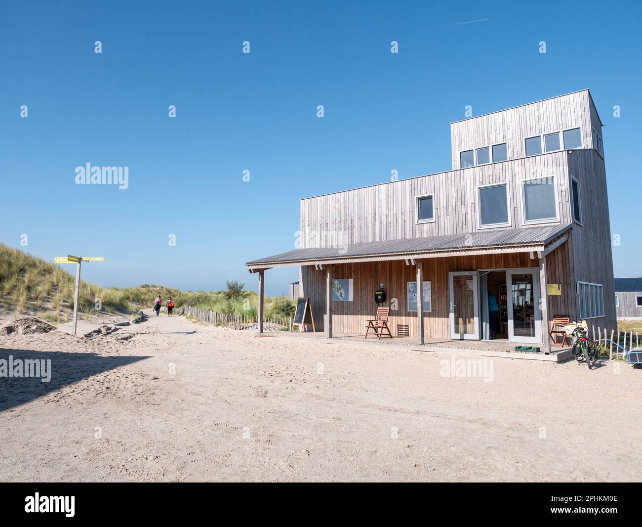 People walking on footpath and sustainable wooden visitor centre on Marker Wadden island, Netherlands Stock Photo