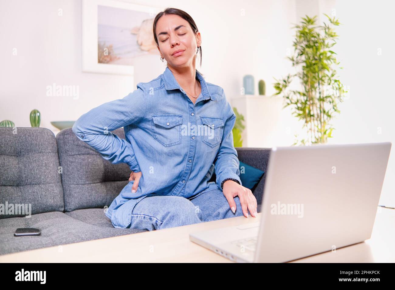 Woman suffering backache and pain caused by poor posture ergonomics