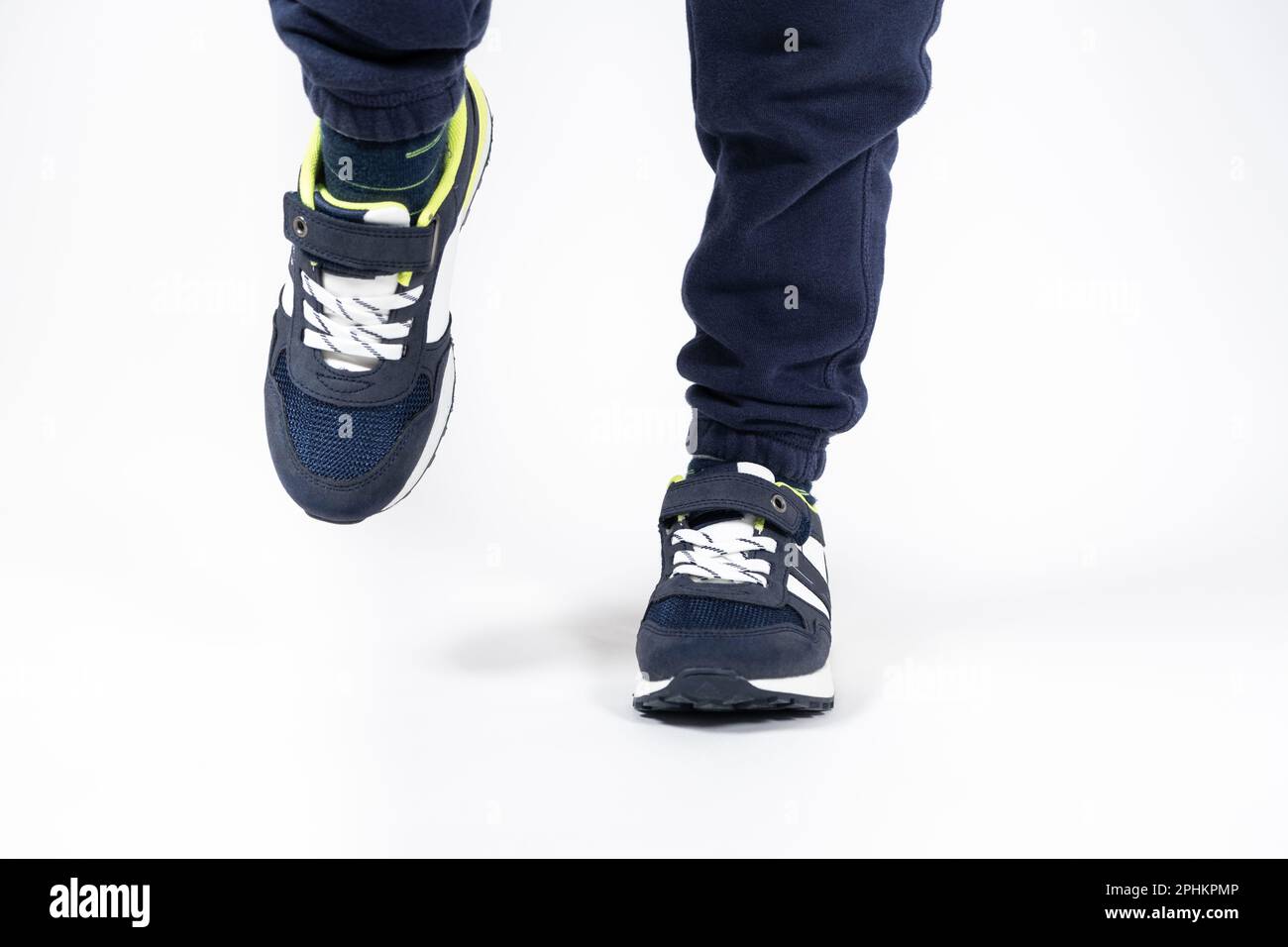 Childrens shoes. Blue kids running shoes sneakers on the legs of a five or sixyearold boy on