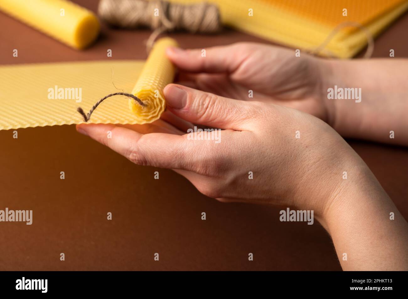 Beeswax candle sheets and jute thread on brown background