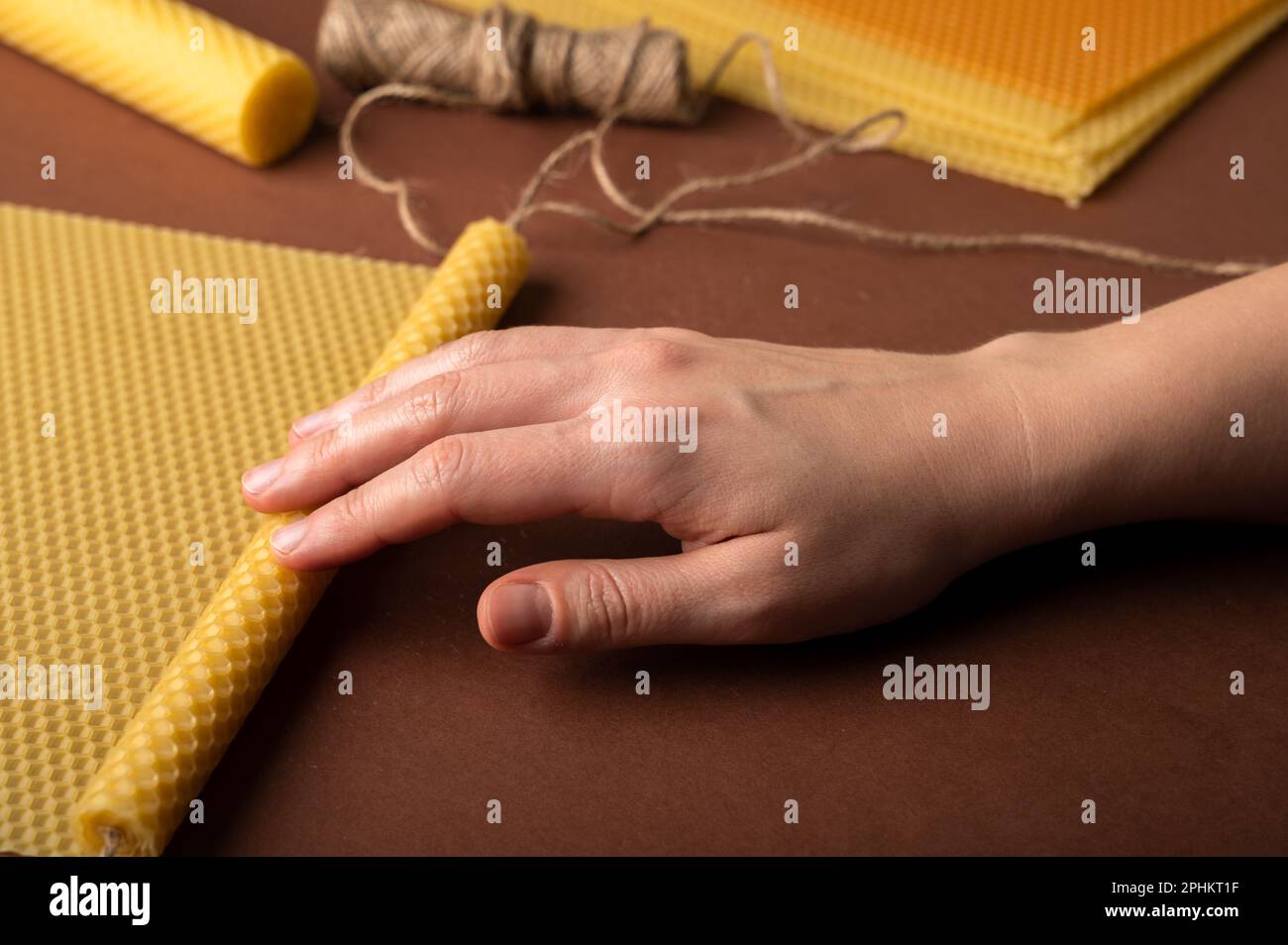 Beeswax candle sheets and jute thread on brown background