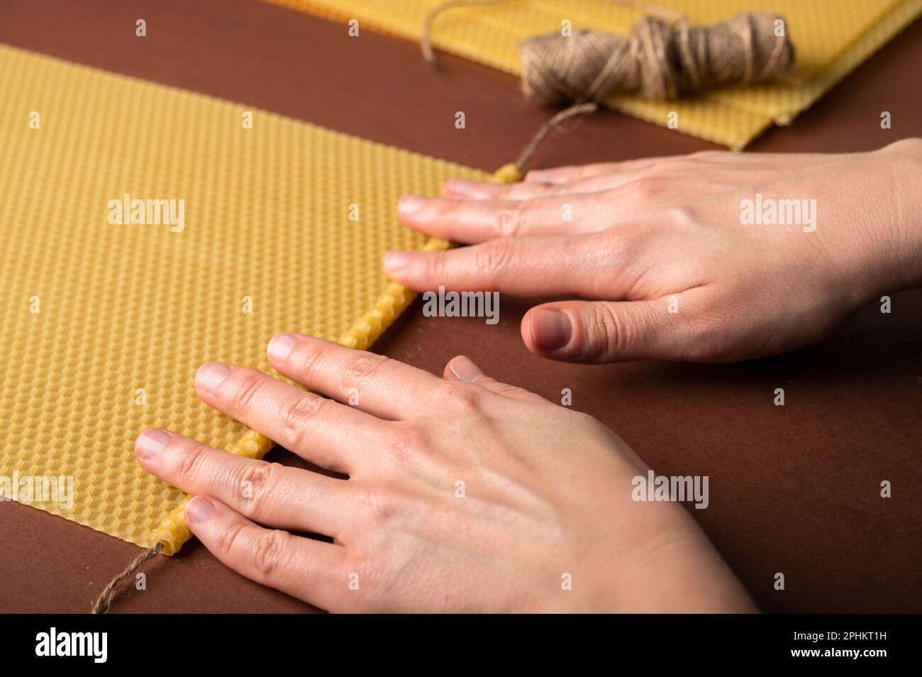 Beeswax candle sheets and jute thread on brown background