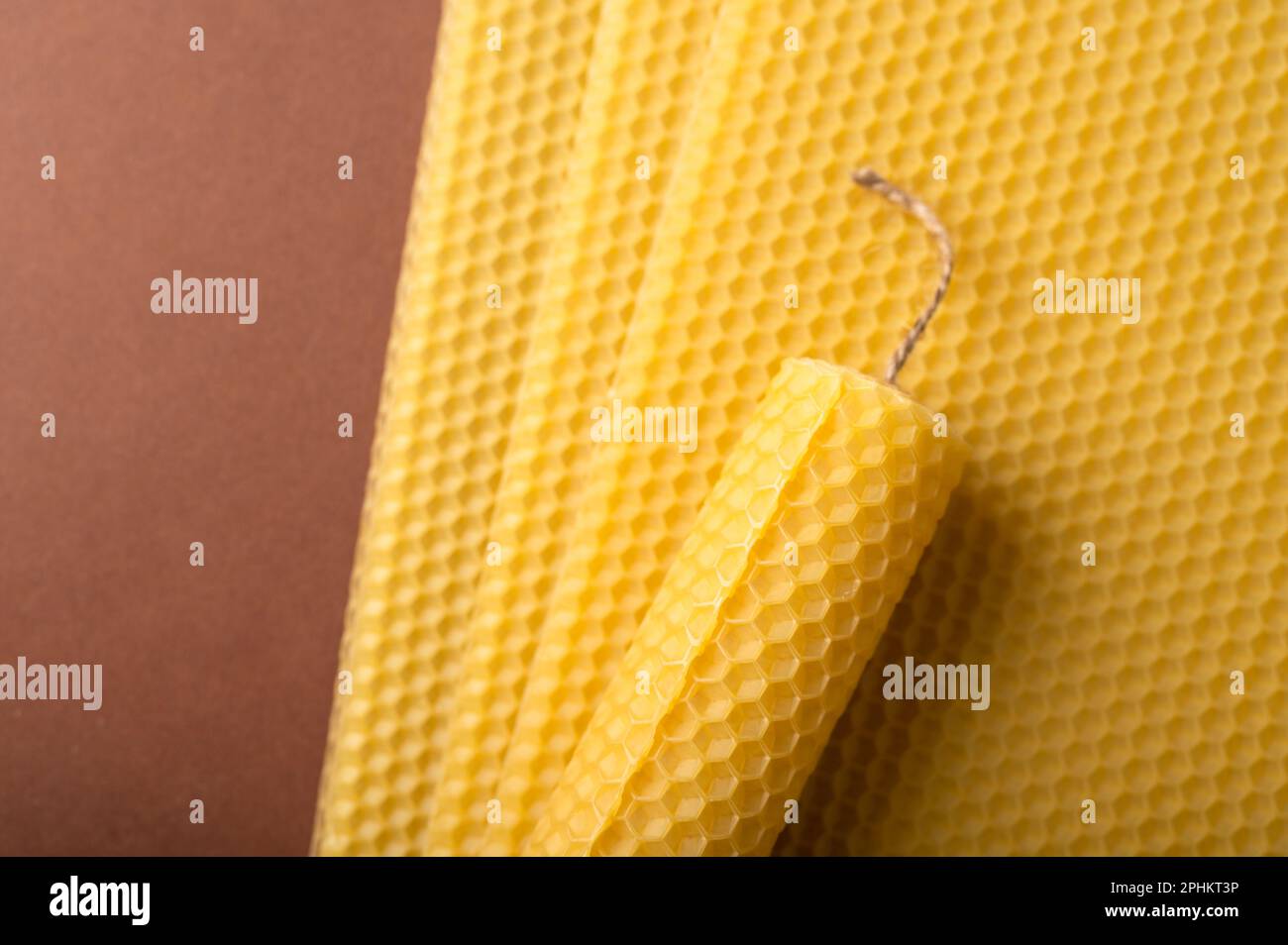 Beeswax candle sheets and jute thread on brown background