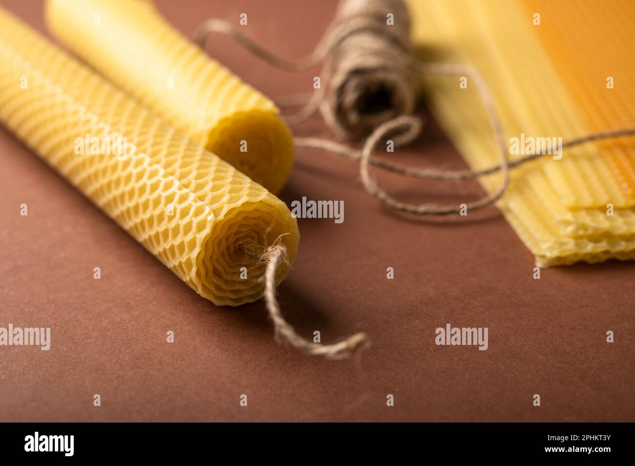 Beeswax candle sheets and jute thread on brown background