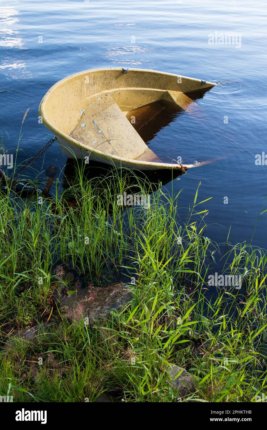 Sunken small motor boat on the shore Stock Photo