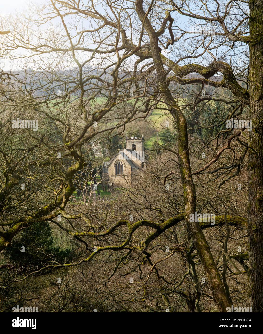 Saint James' Church, Taxal framed by winter trees, in the High Peak, Derbyshire. An ancient parish church in the English landscape on a winter walk Stock Photo