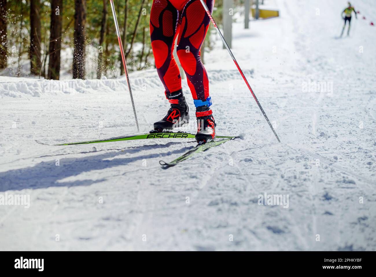 skier athlete running uphill in skiing competition, Fischer racing skis, Rossignol ski boots, HuTag frid tag in legs, winter olympic sports Stock Photo