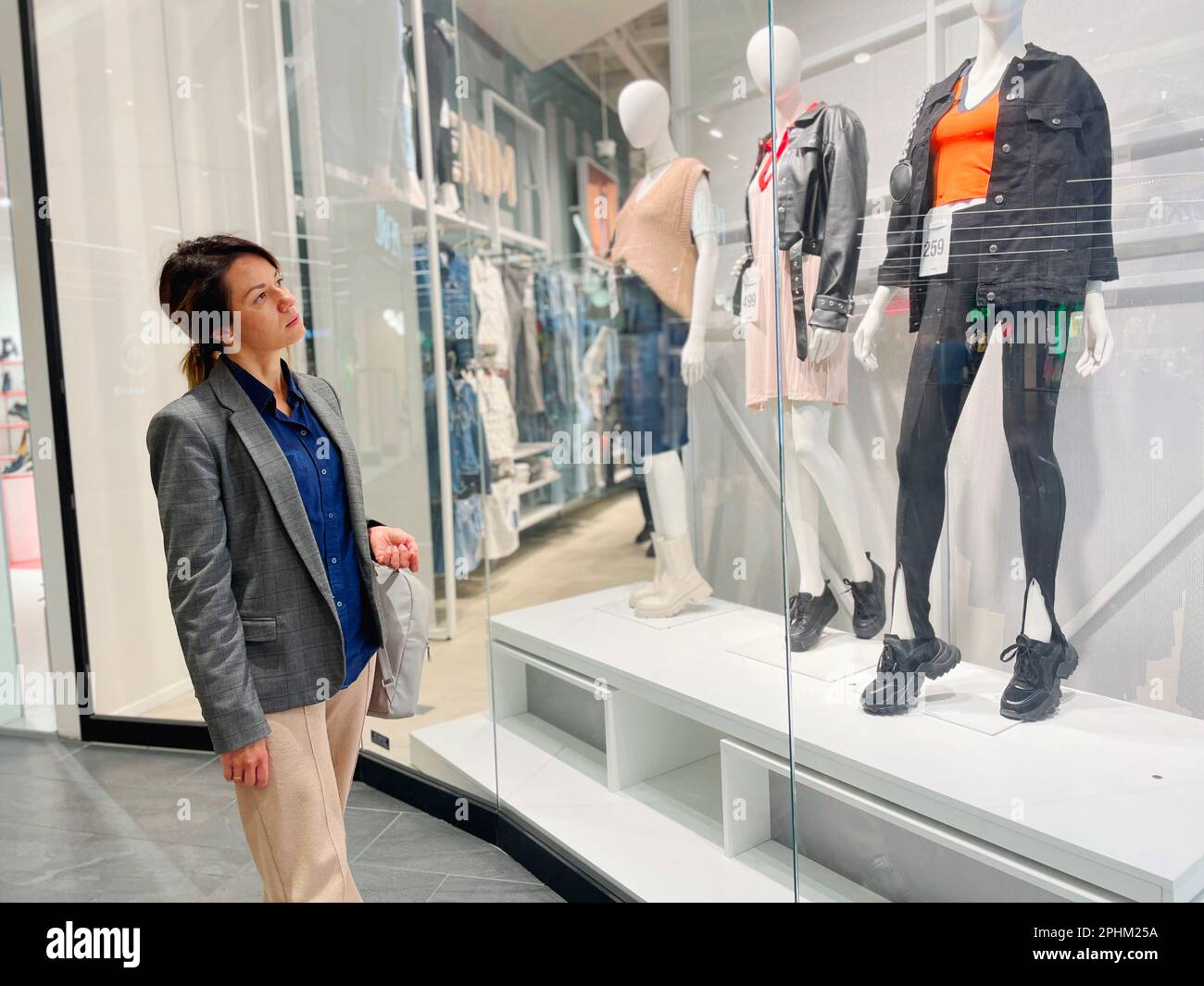 Female mannequins standing in store window display of women casual