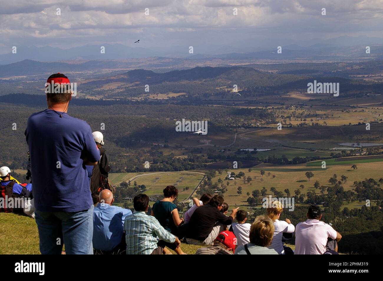 Group of spectators on Tamborine Mountain watching hanggliders and
