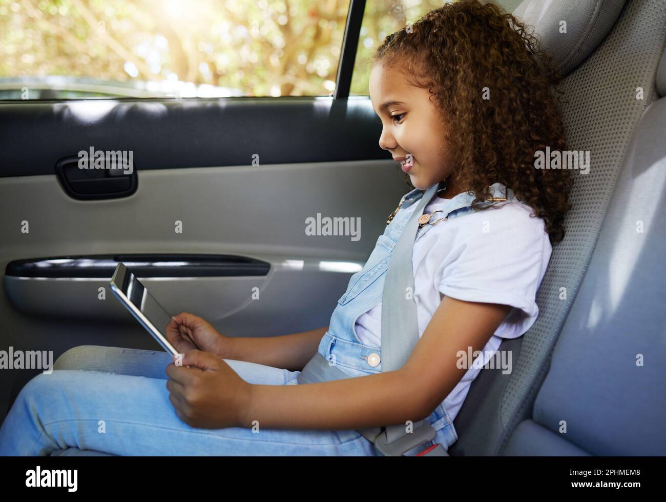 Happy, road trip and a child in a car with a tablet for a movie