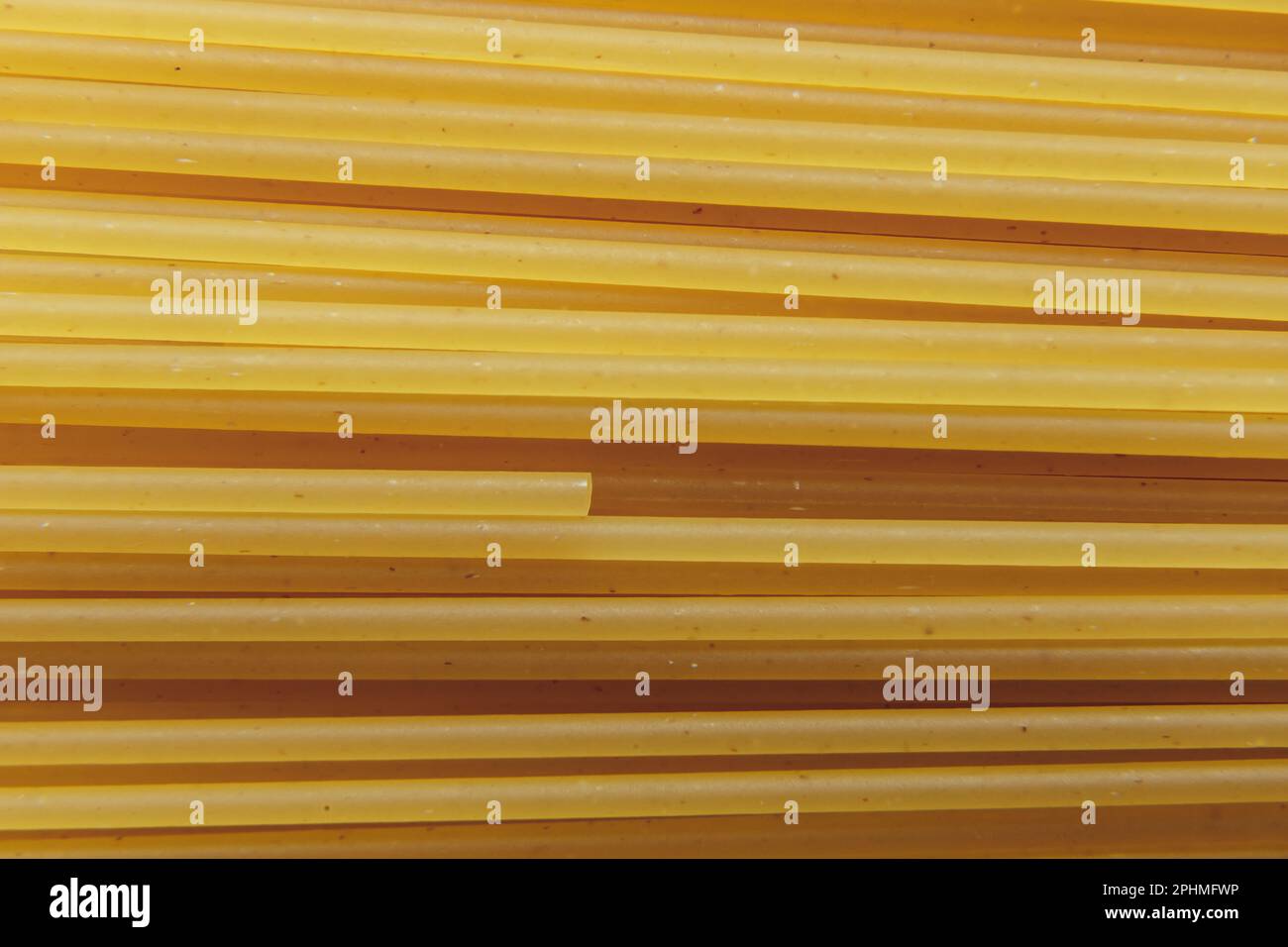 Raw yellow long spaghetti macro photo, background. Raw spaghetti
