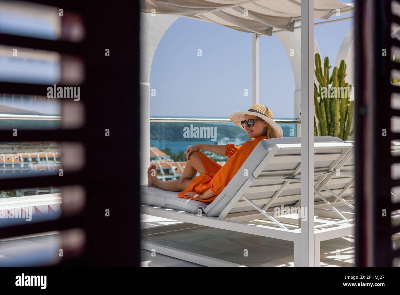 smiling woman relaxing in sunbed and enjoy the summer vacation at luxury villa terrace with seaview Stock Photo