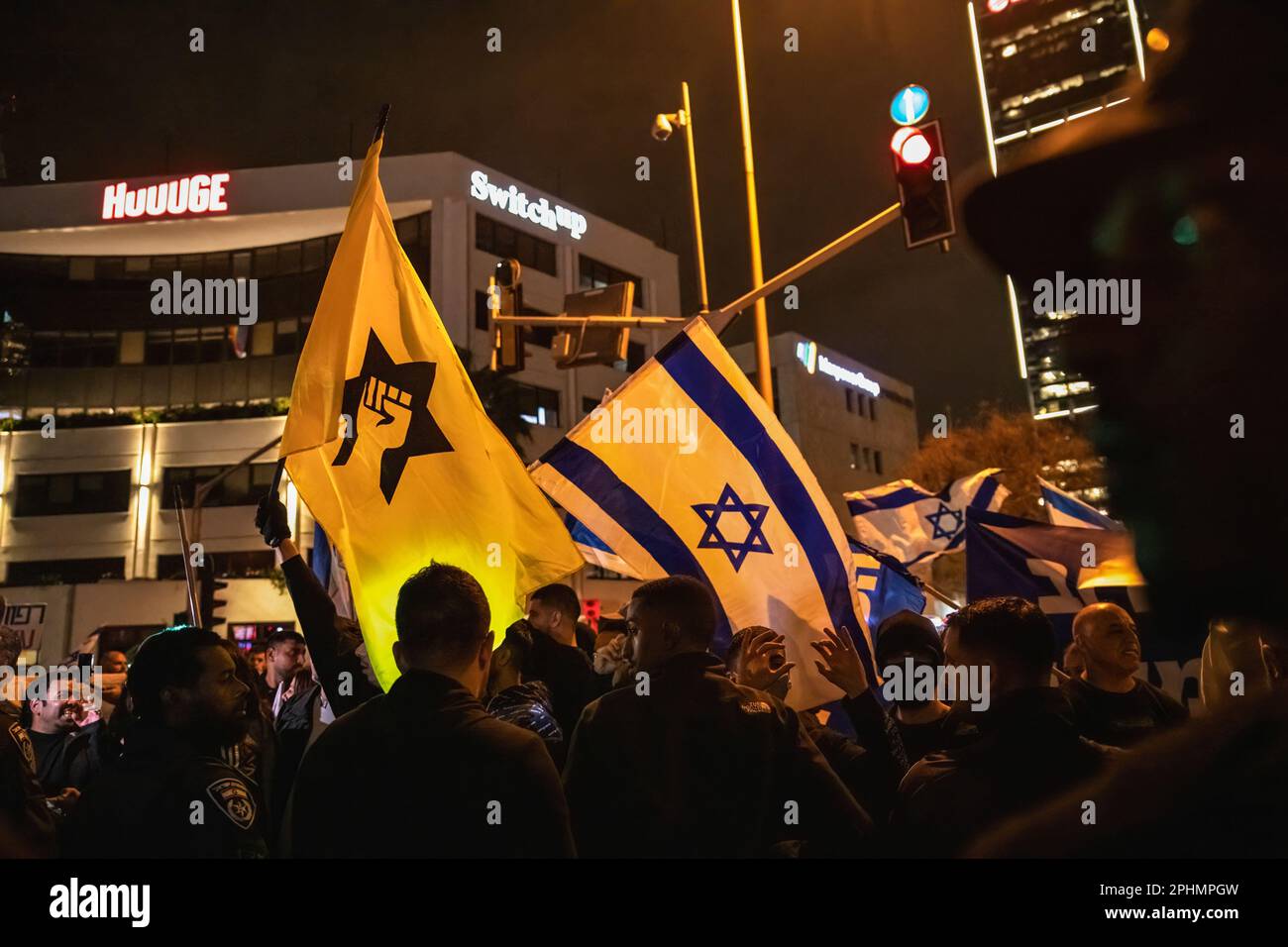 Tel Aviv, Israel. 25th Mar, 2023. Pro-reform protesters wave the Israeli flag center and the Yellow flag of the band Jewish terror movement Kach as police officers separate them from pro-reform protesters during an anti-reform demonstration in Tel Aviv. Over 230,000 people protest in Tel Aviv against Netanyahu's far-right government and its controversial legal reform. Credit: SOPA Images Limited/Alamy Live News Stock Photo