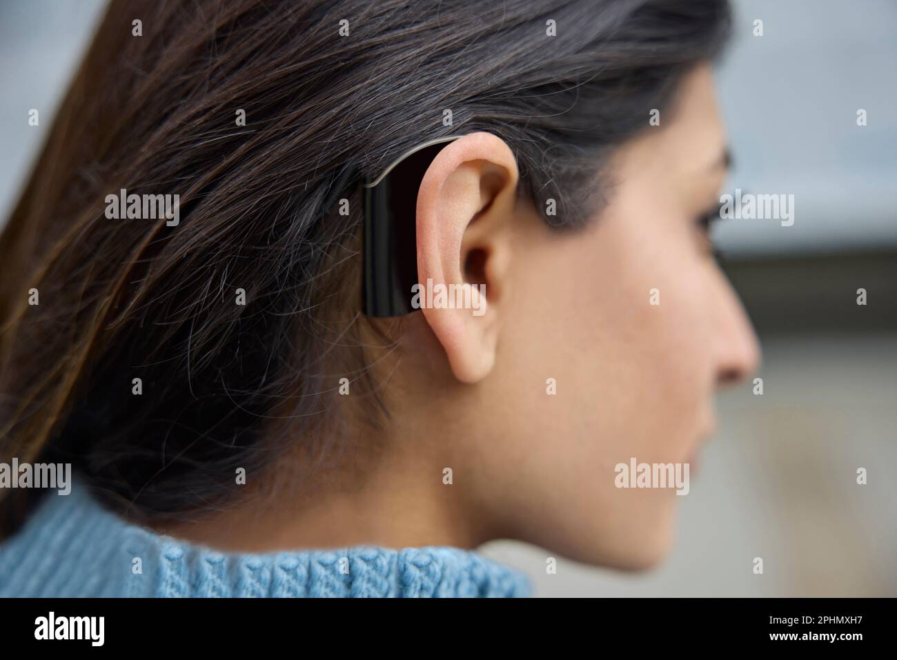 Close Up Of Young Woman Wearing Behind The Ear Hearing Device Or Aid Stock Photo