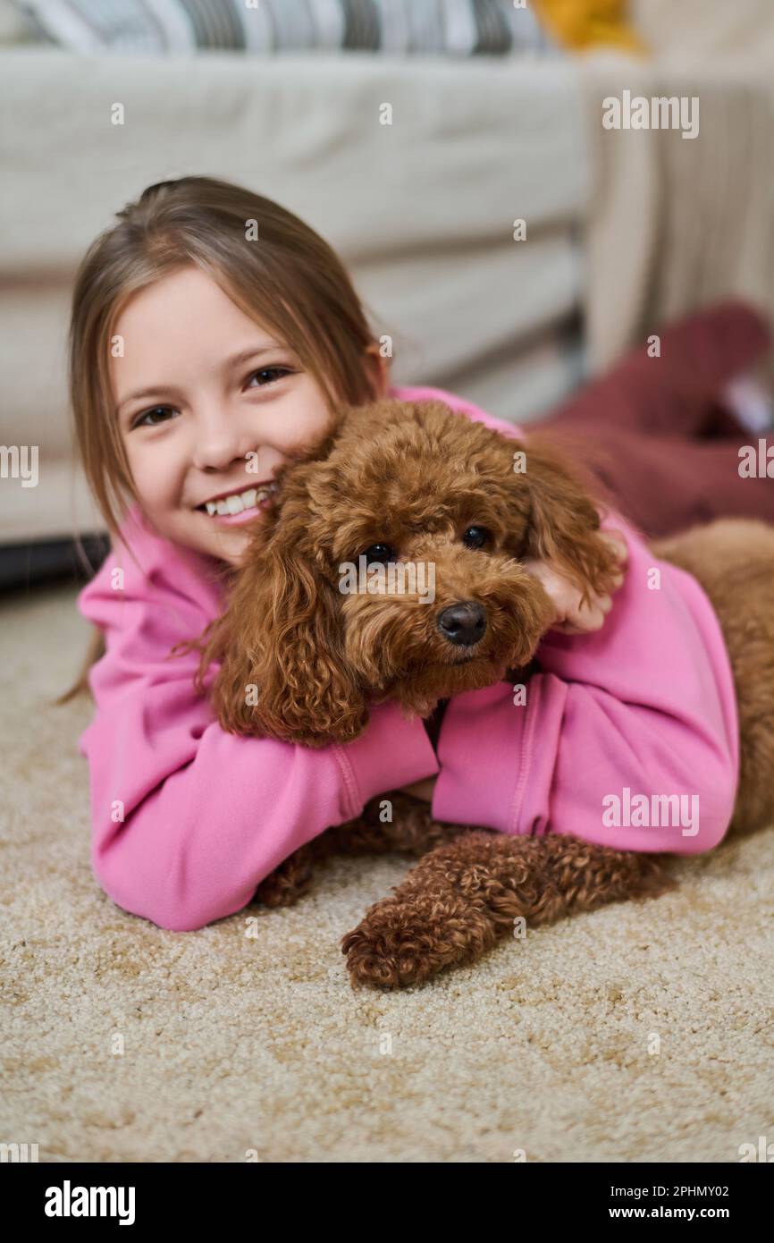 Portrait of little girl smiling at camera while playing on the floor ...