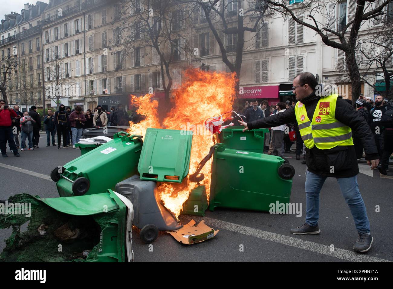 PARIS, France. 28th Mar, 2023. A protester throws rubbish onto a fire at a demonstration in Paris over pension reform. President Macron wants to introduce a bill which will raise the retirement age from 62 to 64. Credit: Lucy North/Alamy Live News Stock Photo