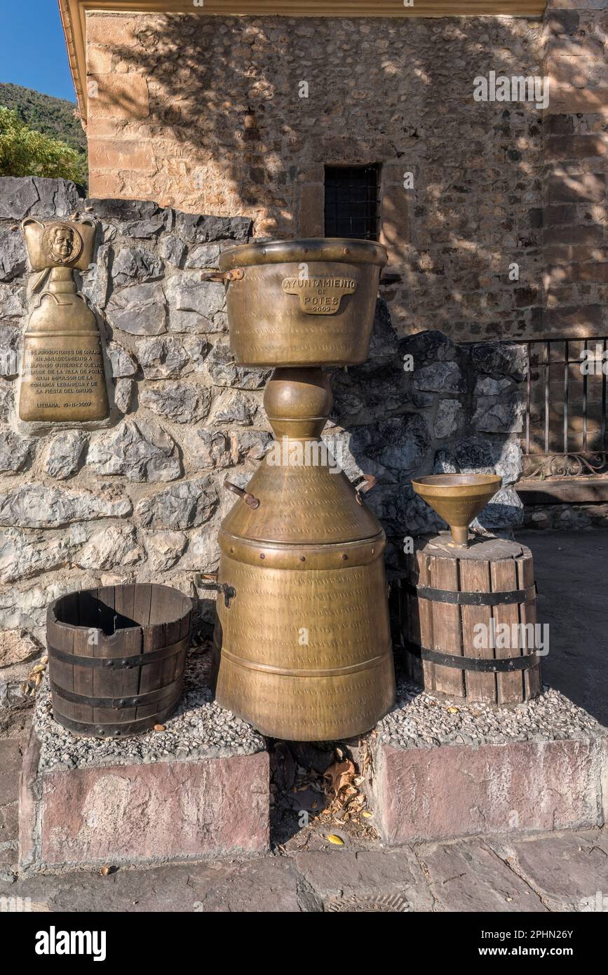 monument to the Alquitara, stone and bronze fountain in the town of Potes, utensil used for the distillation of the Orujo de Liébana, Cantabria, Spain Stock Photo