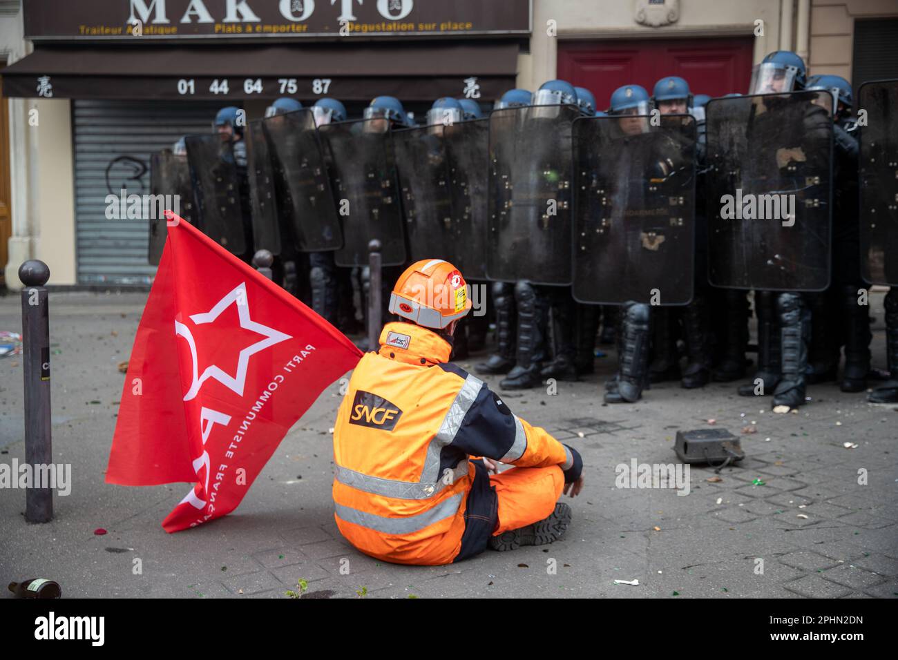 PARIS, France. 28th Mar, 2023. A member of the SNCF sits in front of the police at a demonstration in Paris over pension reform. President Macron wants to introduce a bill which will raise the retirement age from 62 to 64. Credit: Lucy North/Alamy Live News Stock Photo