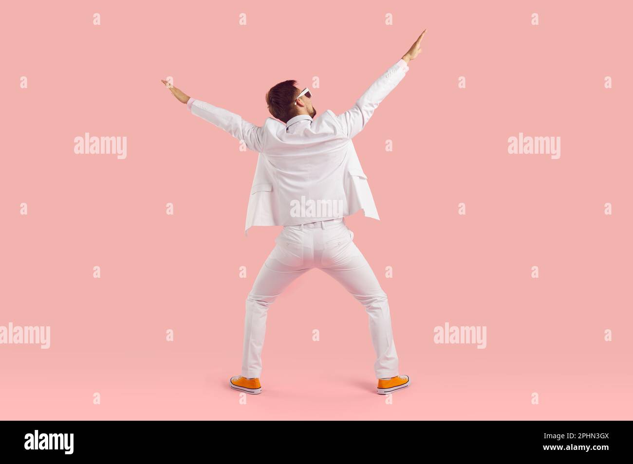 Funny inspired man in white suit performs energetic fashionable dance