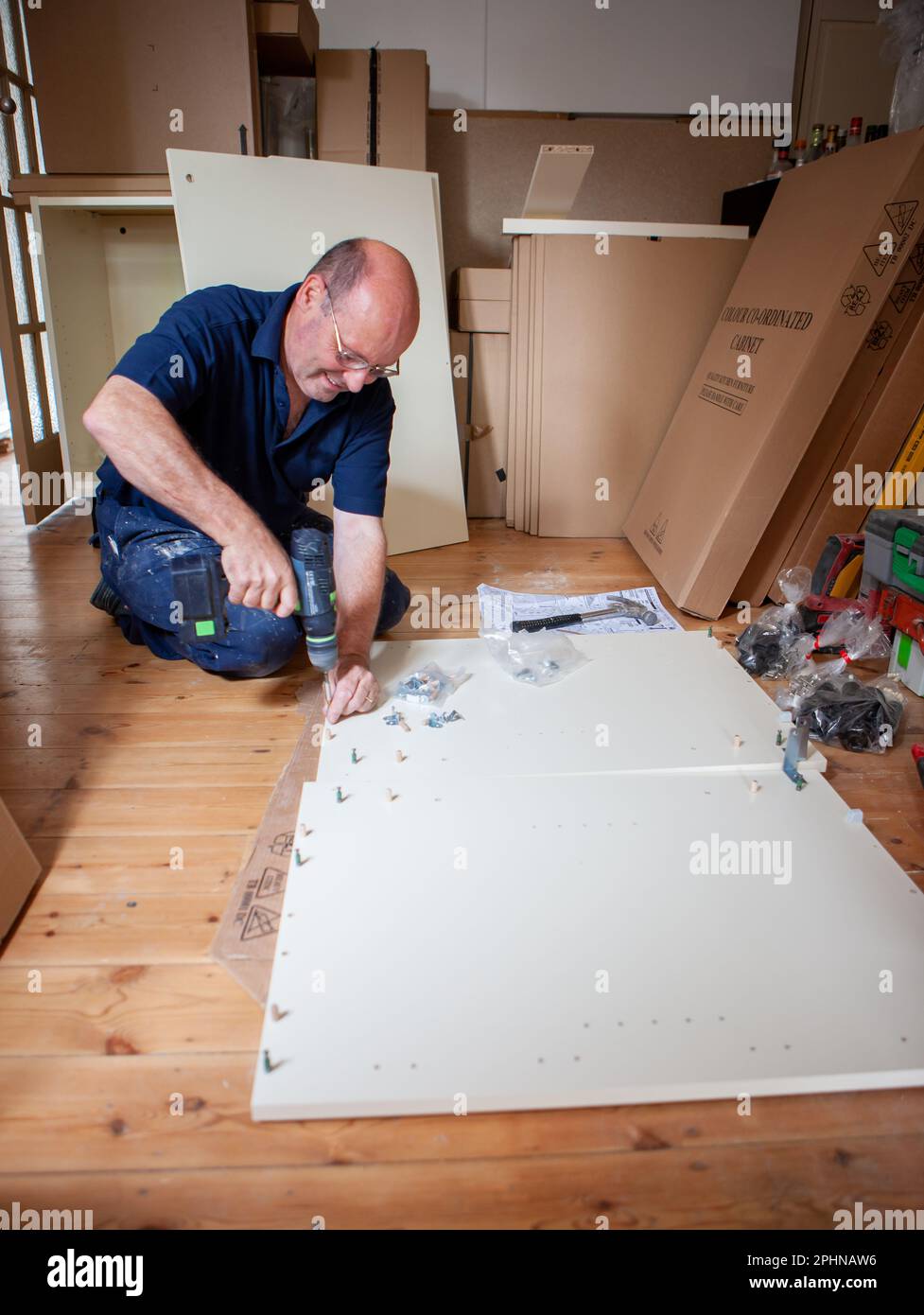 Kitchen Fitters Flat Pack Construction. A joiner starting construction on the flat pack