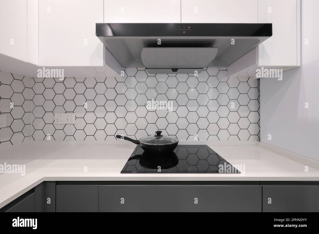 Frying pan on electric stove in the kitchen with kitchen hood Stock Photo Alamy