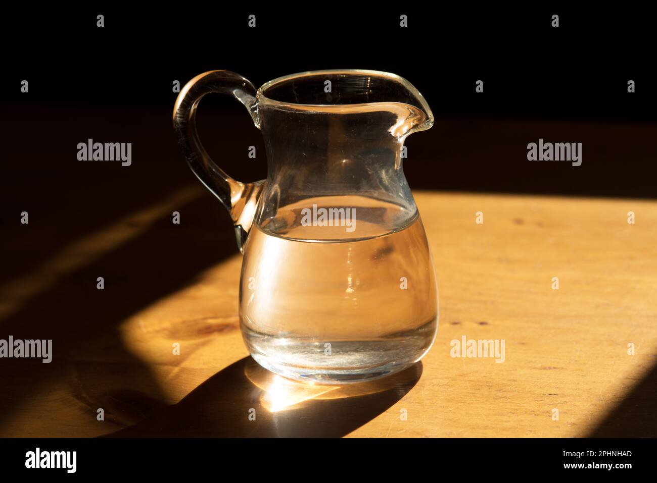 una bella caraffa in vetro con dell'acqua su un tavolo in legno Stock Photo