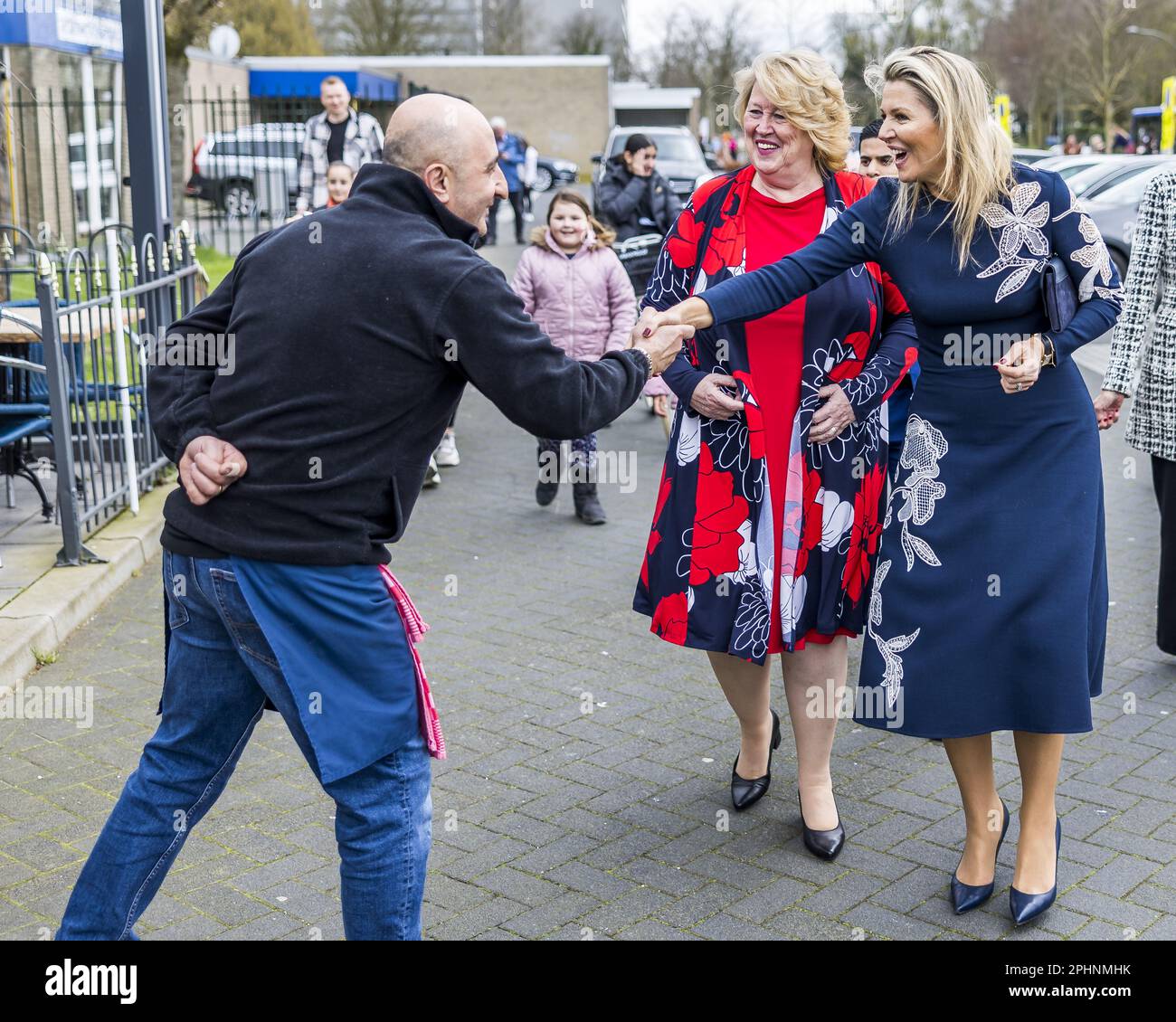 ROERMOND - Queen Maxima is welcomed by a passer-by on her way to DB4ALL  Kookt. Here she received an explanation of the activities of the young  people and the production chain of