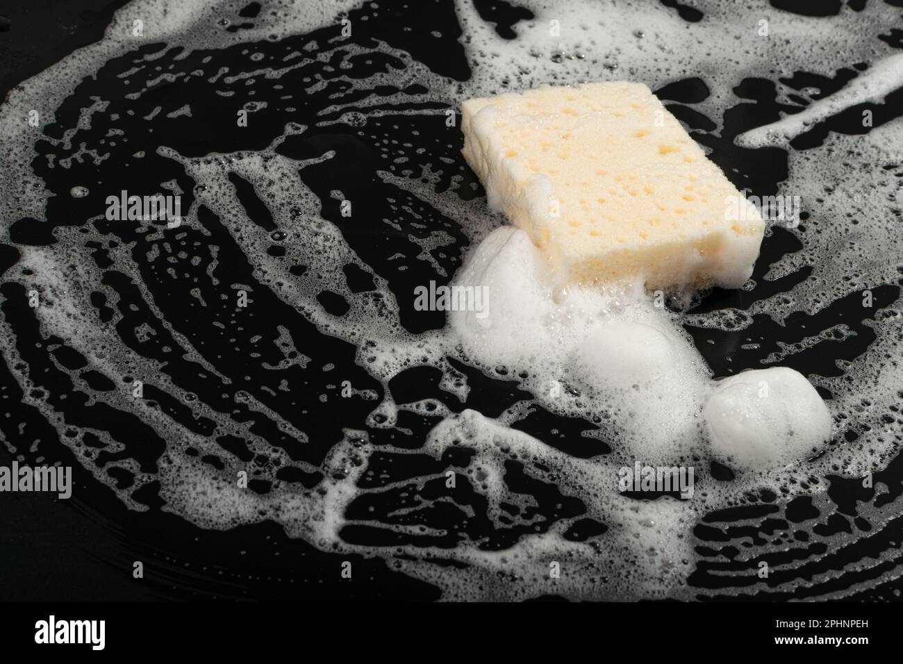 Natural Soapy Sponge with Foam, Eco Brown Sponges, Eco Friendly Hygiene Accessory, Scotch Brite Dishwasher on Black Background, Copy Space Stock Photo