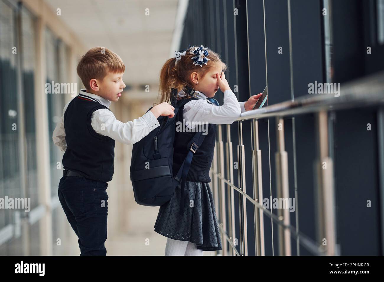 A little schoolboy steals things from a girl's bag while she is