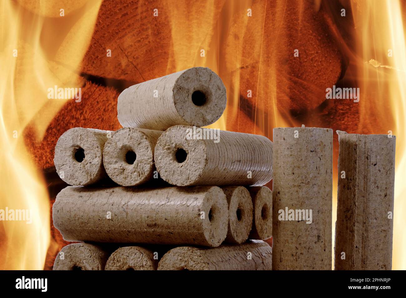 round stacked wooden briquettes in front of fire Stock Photo